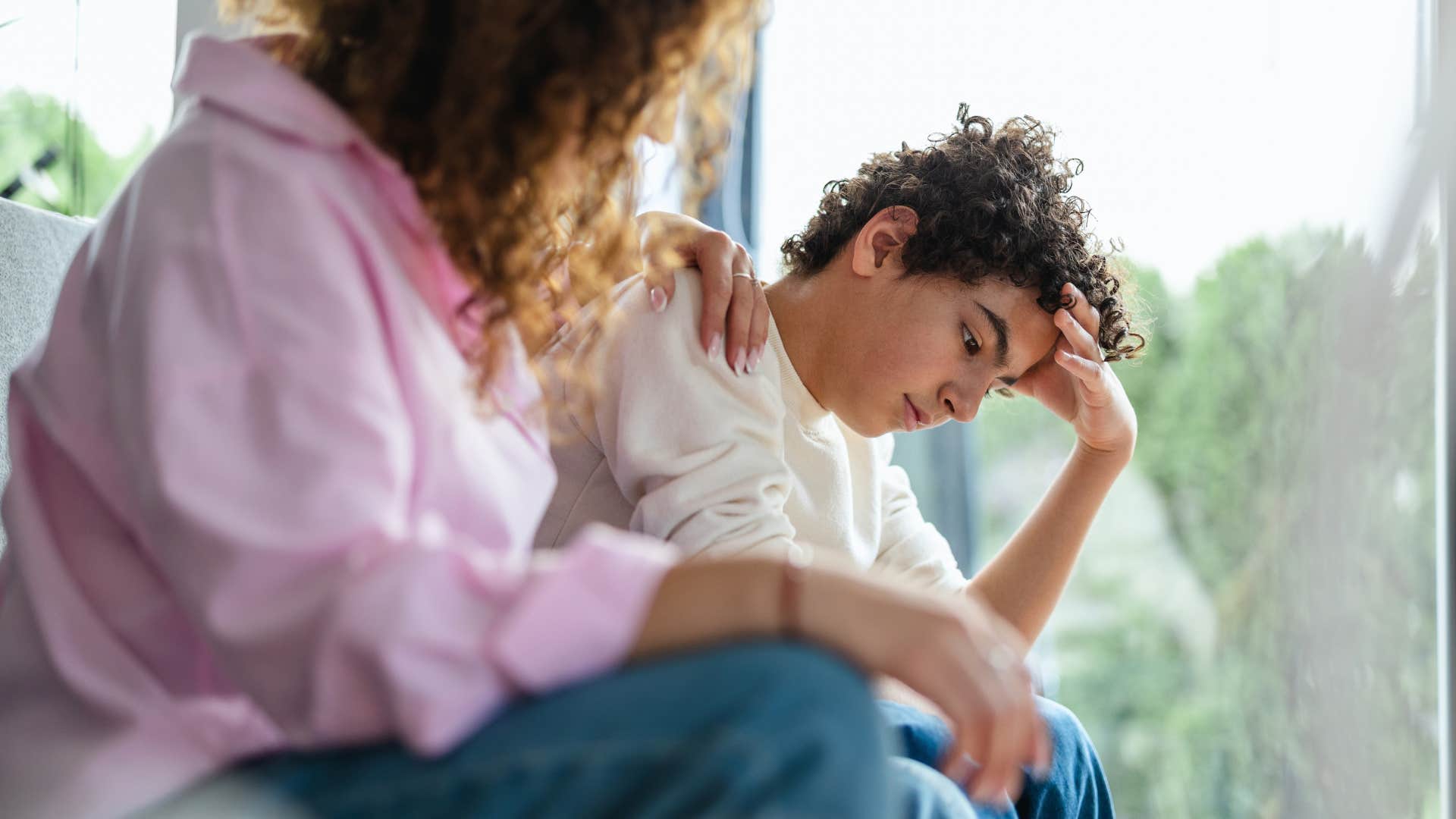 woman comforting teenage son after disciplining him