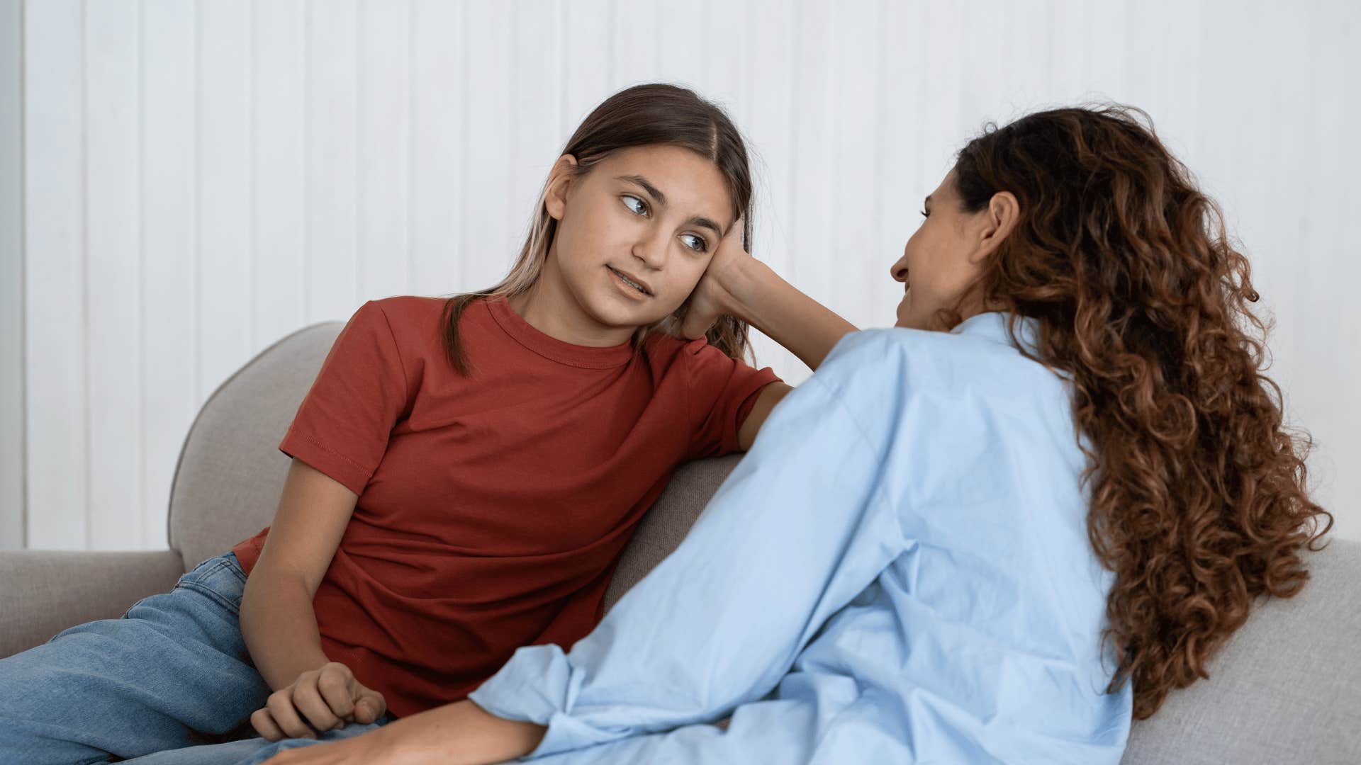 mother talking to daughter on couch