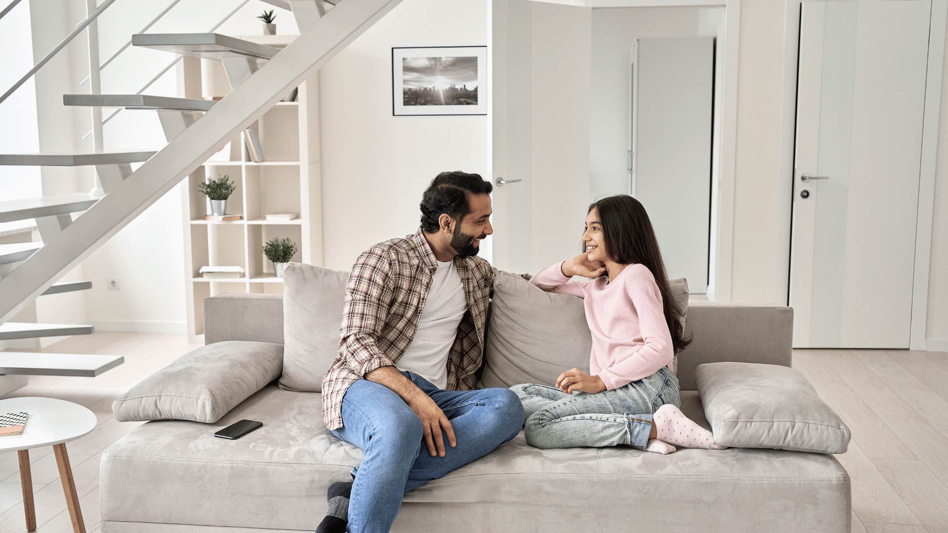 father talking to daughter on couch