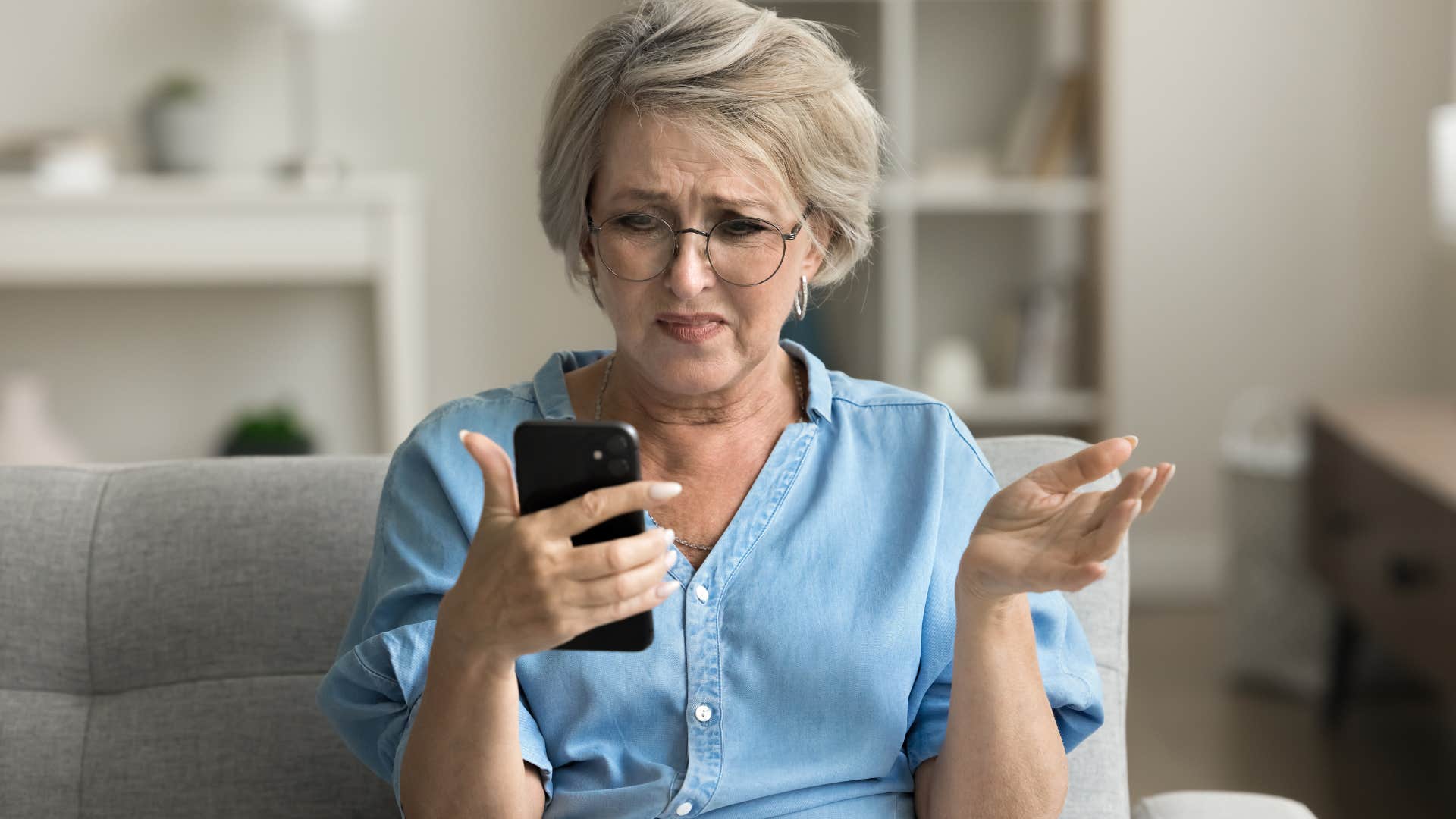 irritated older woman talking to adult child on speakerphone