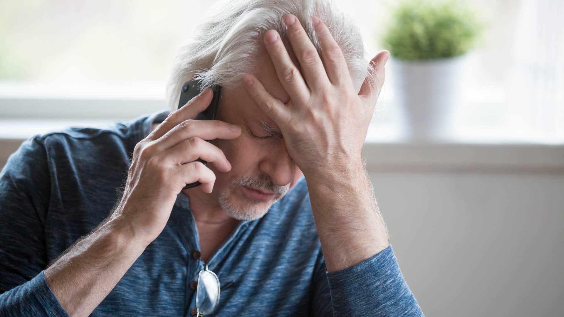 stressed boomer man holding his forehead