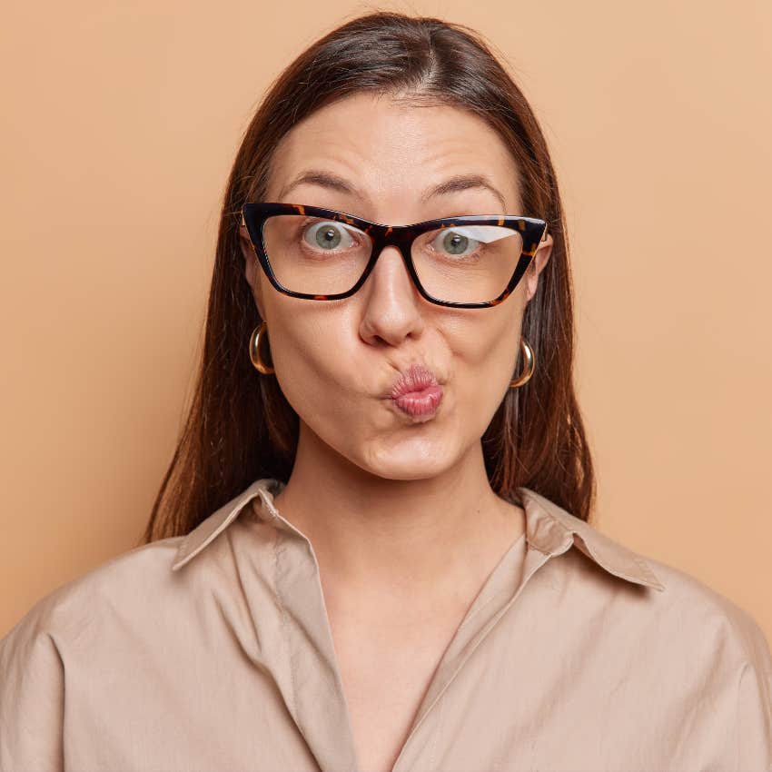 woman with glasses pursing her lips