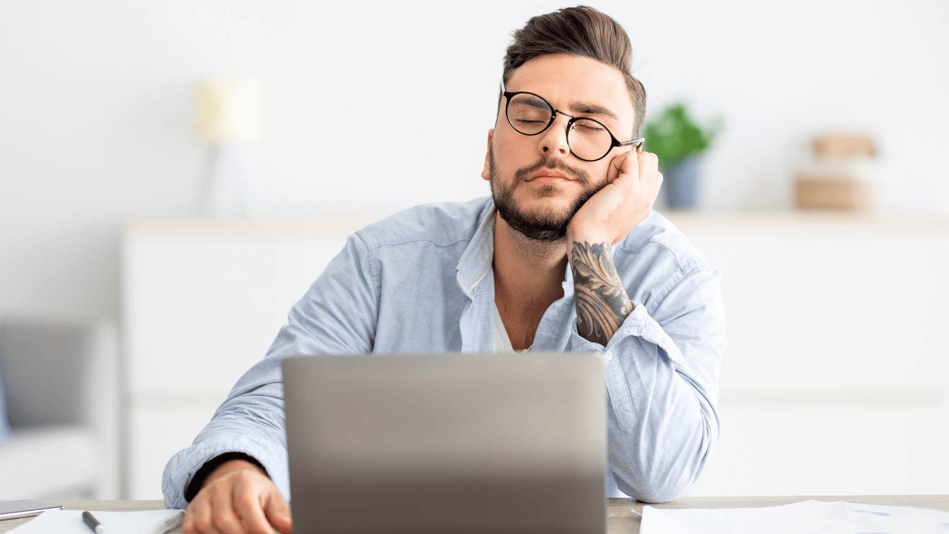 man napping in front of his laptop