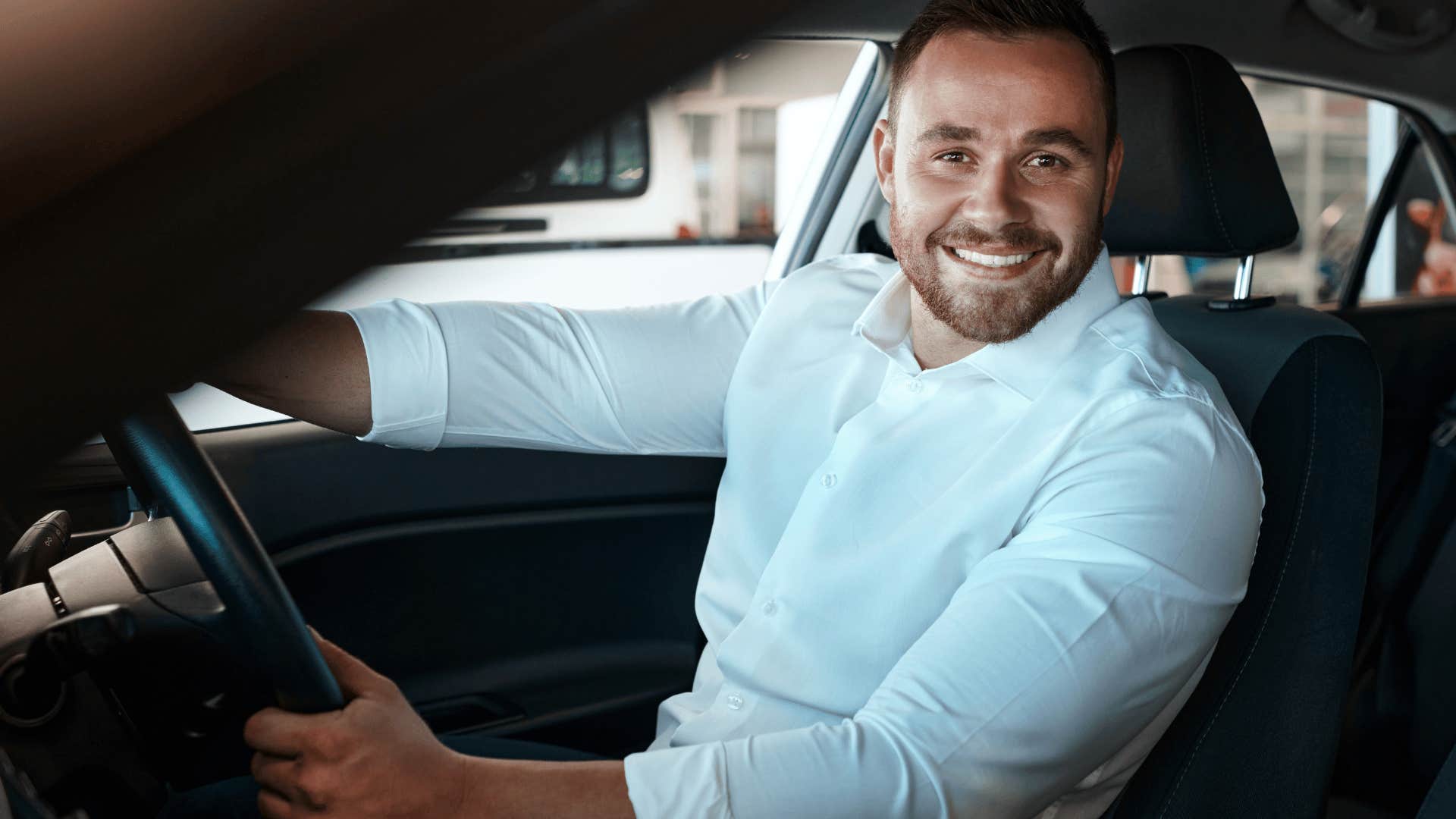 professional man smiling driving a car