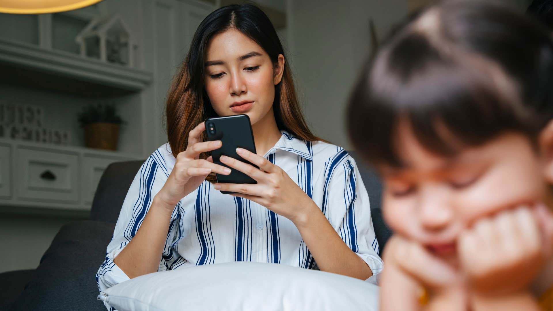 distracted mom ignoring young daughter