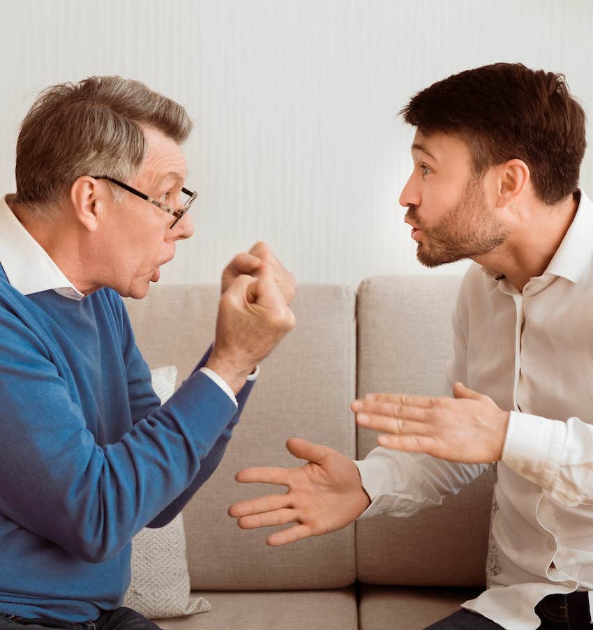 Older man makes fist hand while arguing with defensive younger man