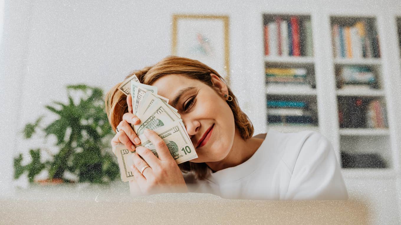 woman holding money showing signs financial growth