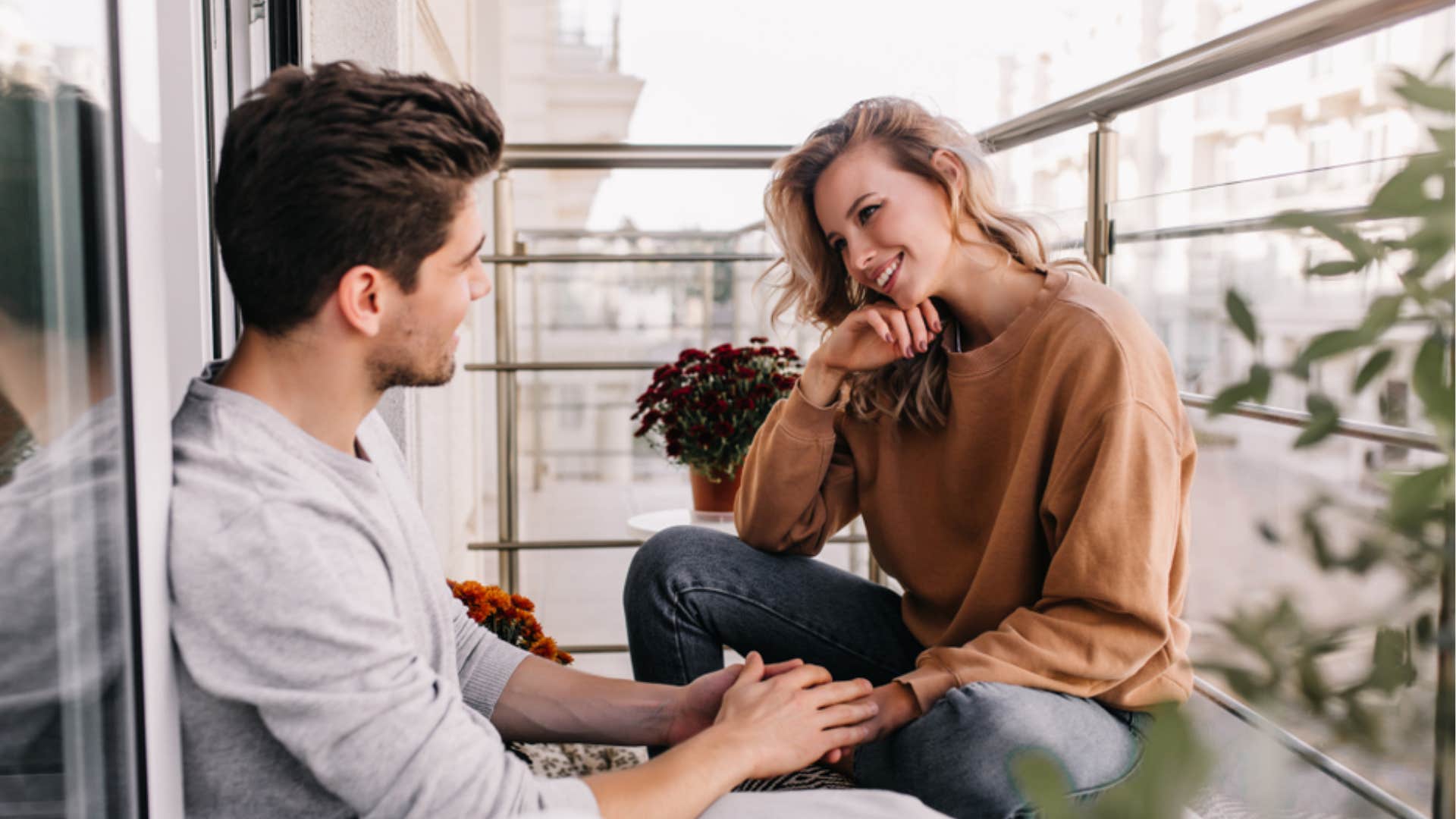 woman listening intently to man speak on balcony