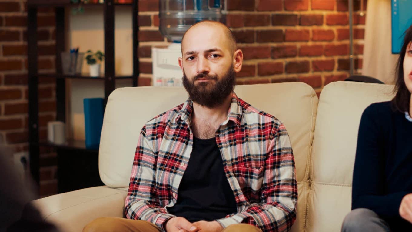 Bald man in office looking sad, doesn't fully trust his partner