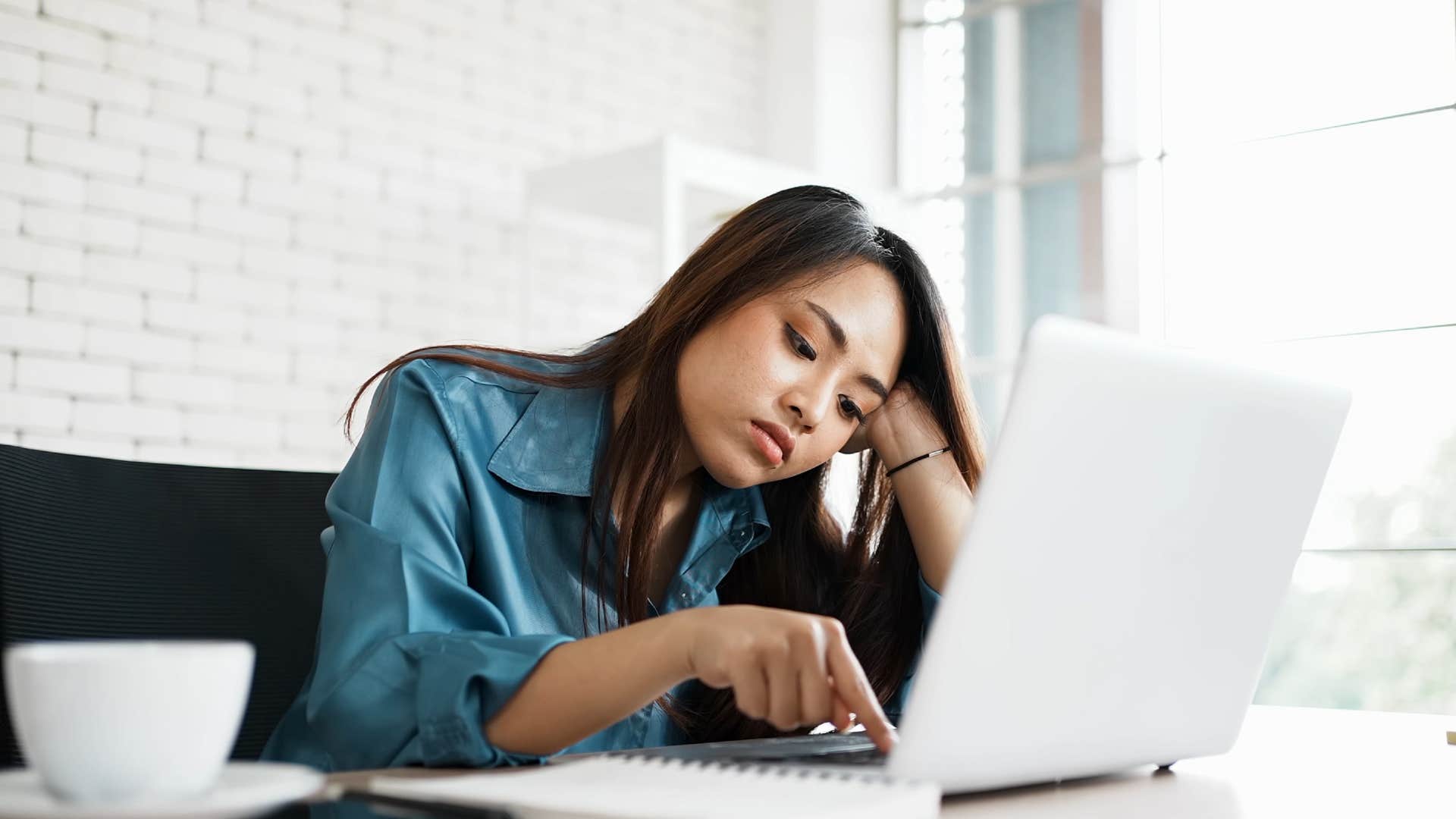 sad indifferent woman working on her computer