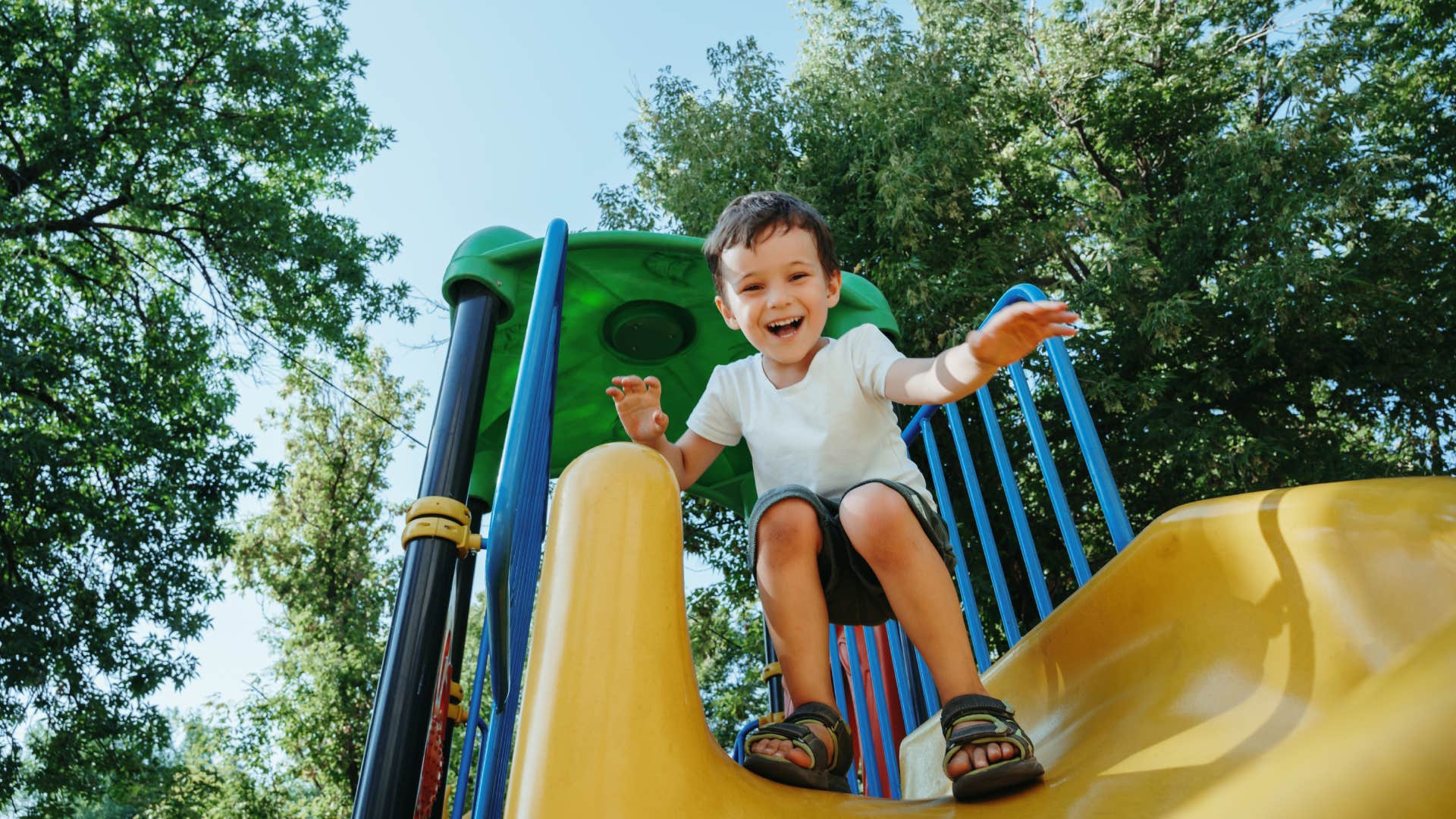 kid playing on slide at park