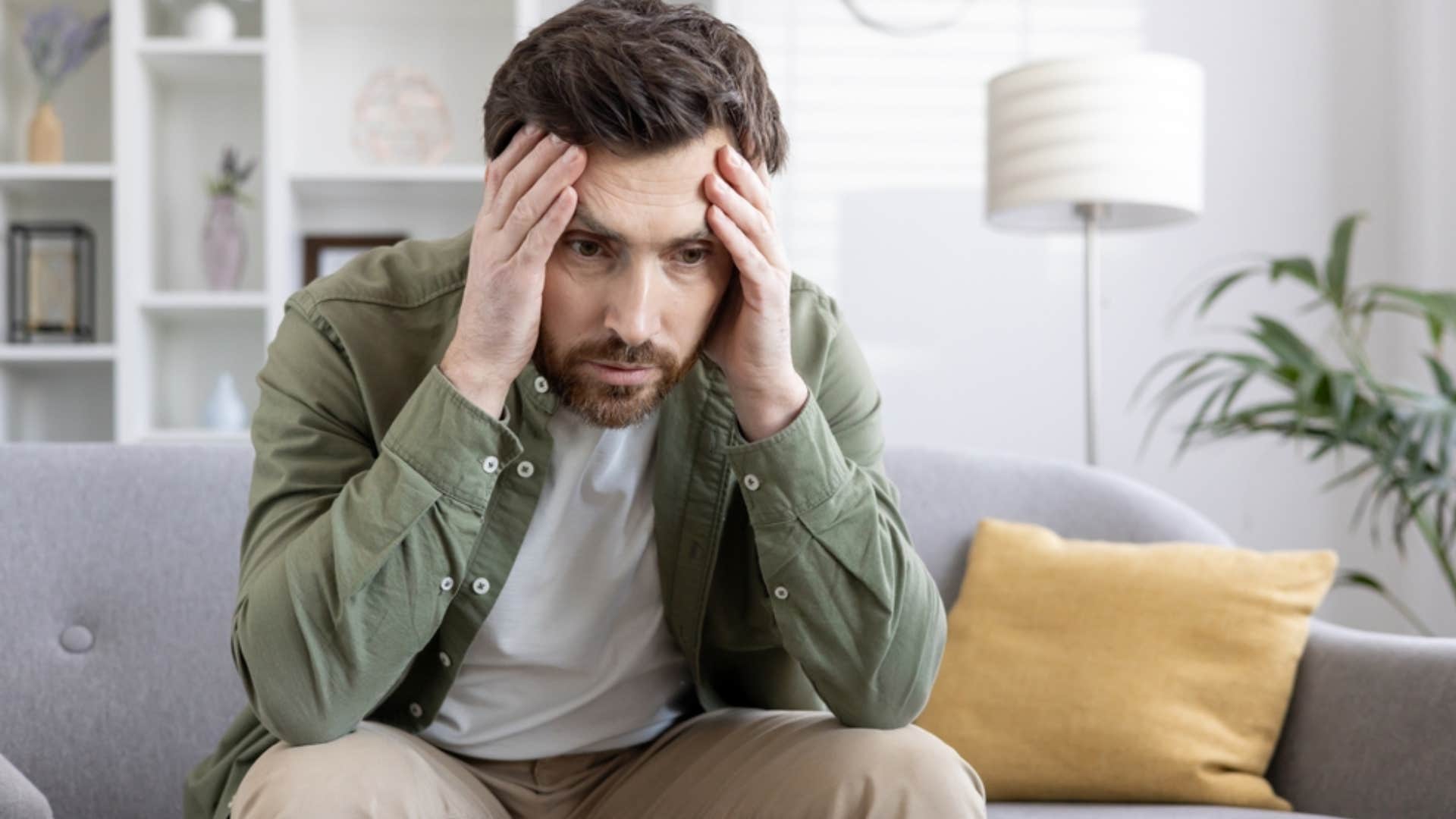 stressed man holding his head