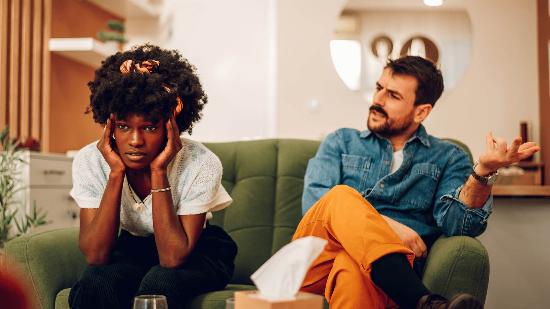 couple arguing sitting on sofa about holding grudges