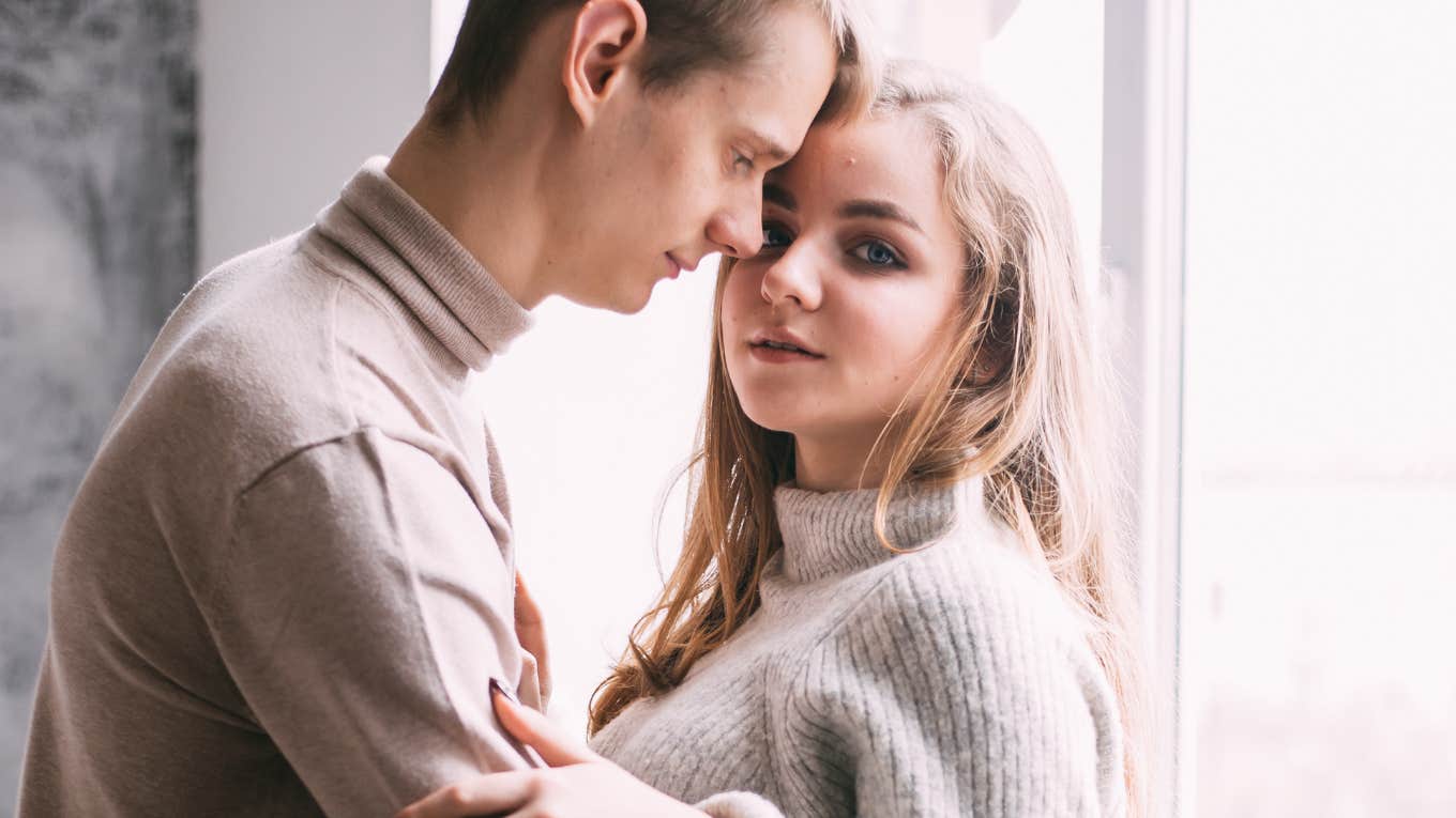 Young couple by a window, woman worried that his behavior is a relationship ender