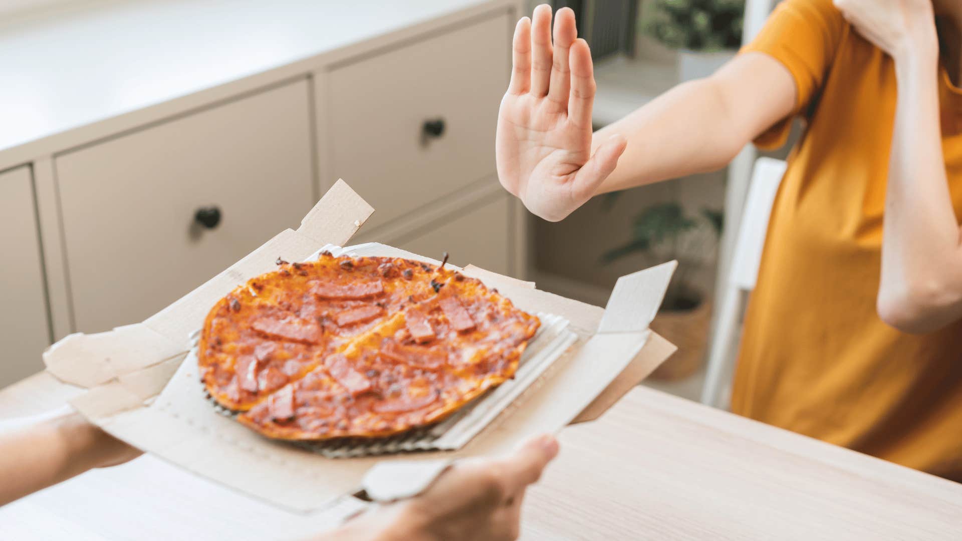 person refusing to eat pizza