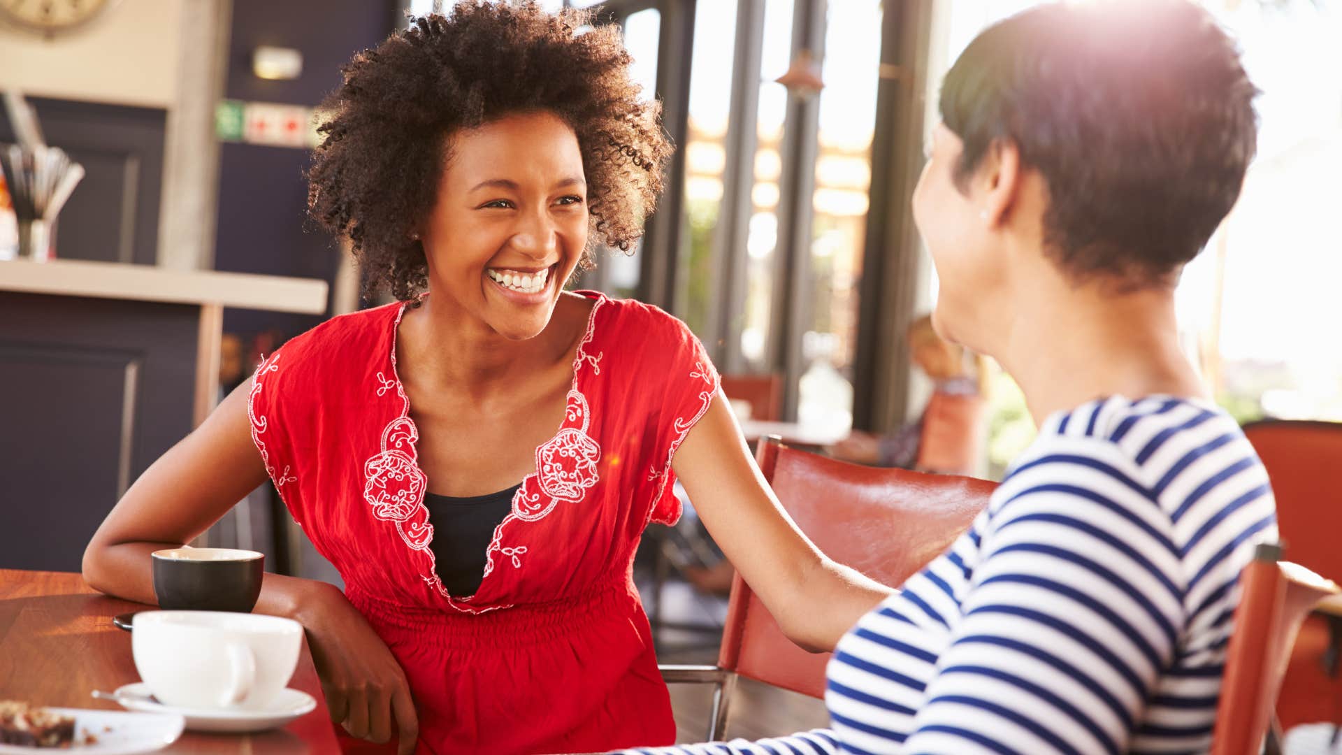 smiling woman talking to friend at lunch