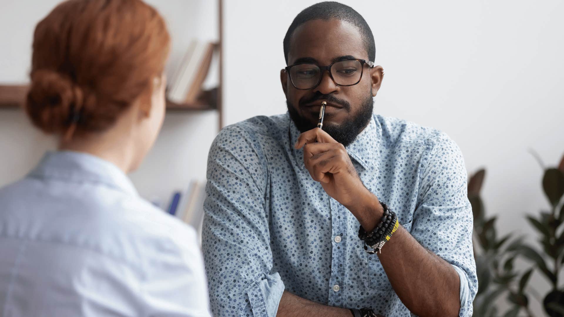 suspicious man talking to woman across from him