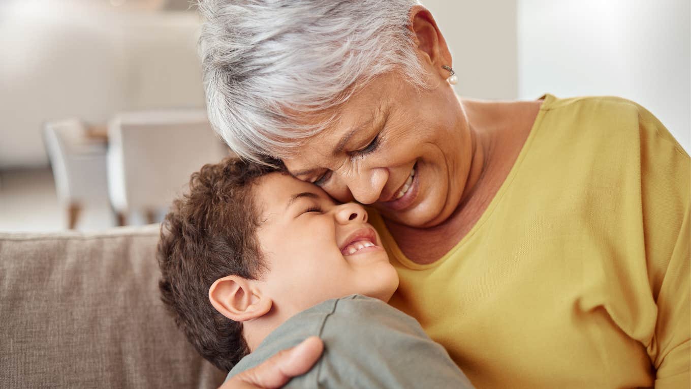 loving grandmother smiling and hugging her grandson