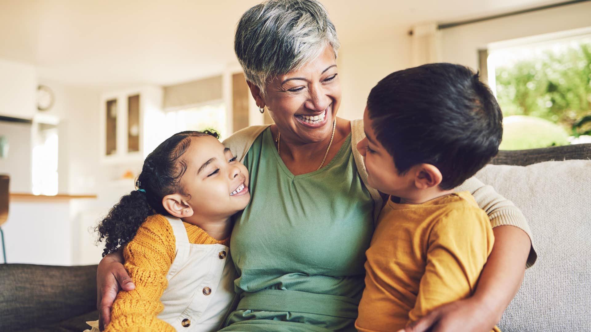 loving grandmother listening to two grandchildren speak