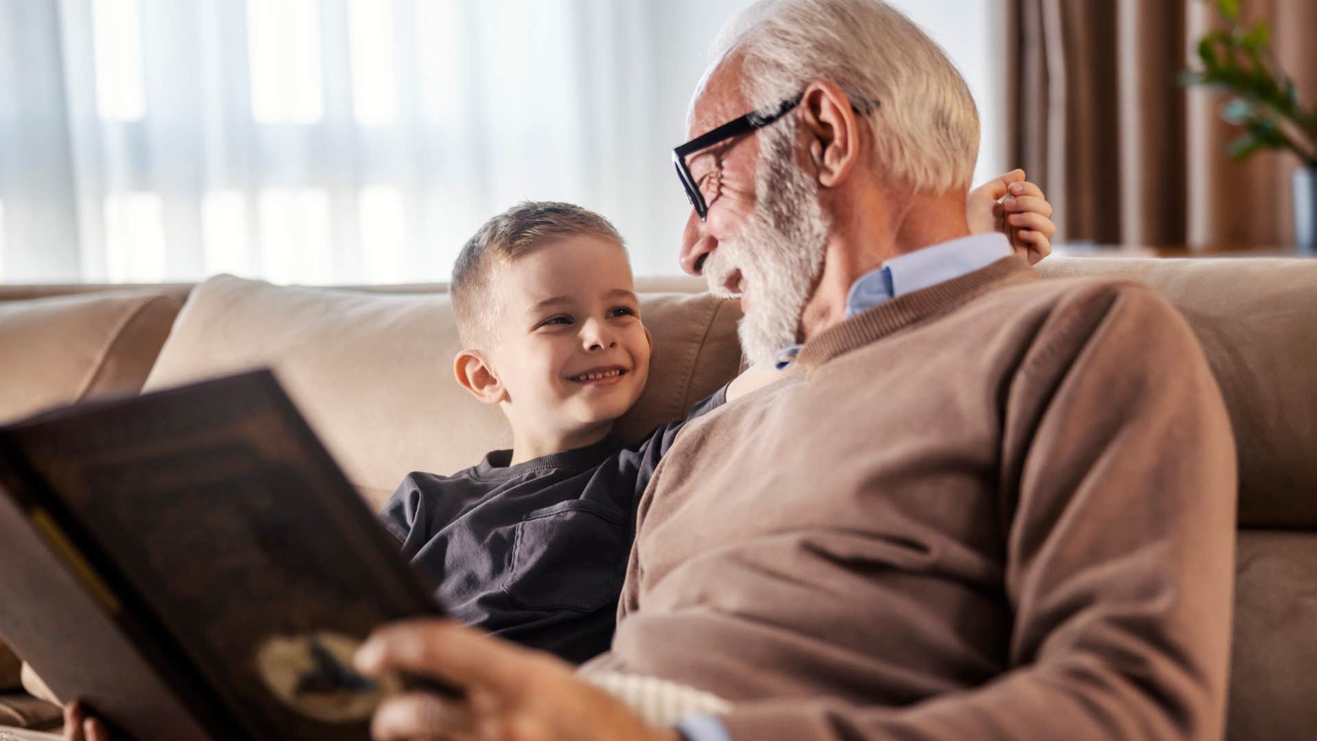 grandfather happily reading with his grandson