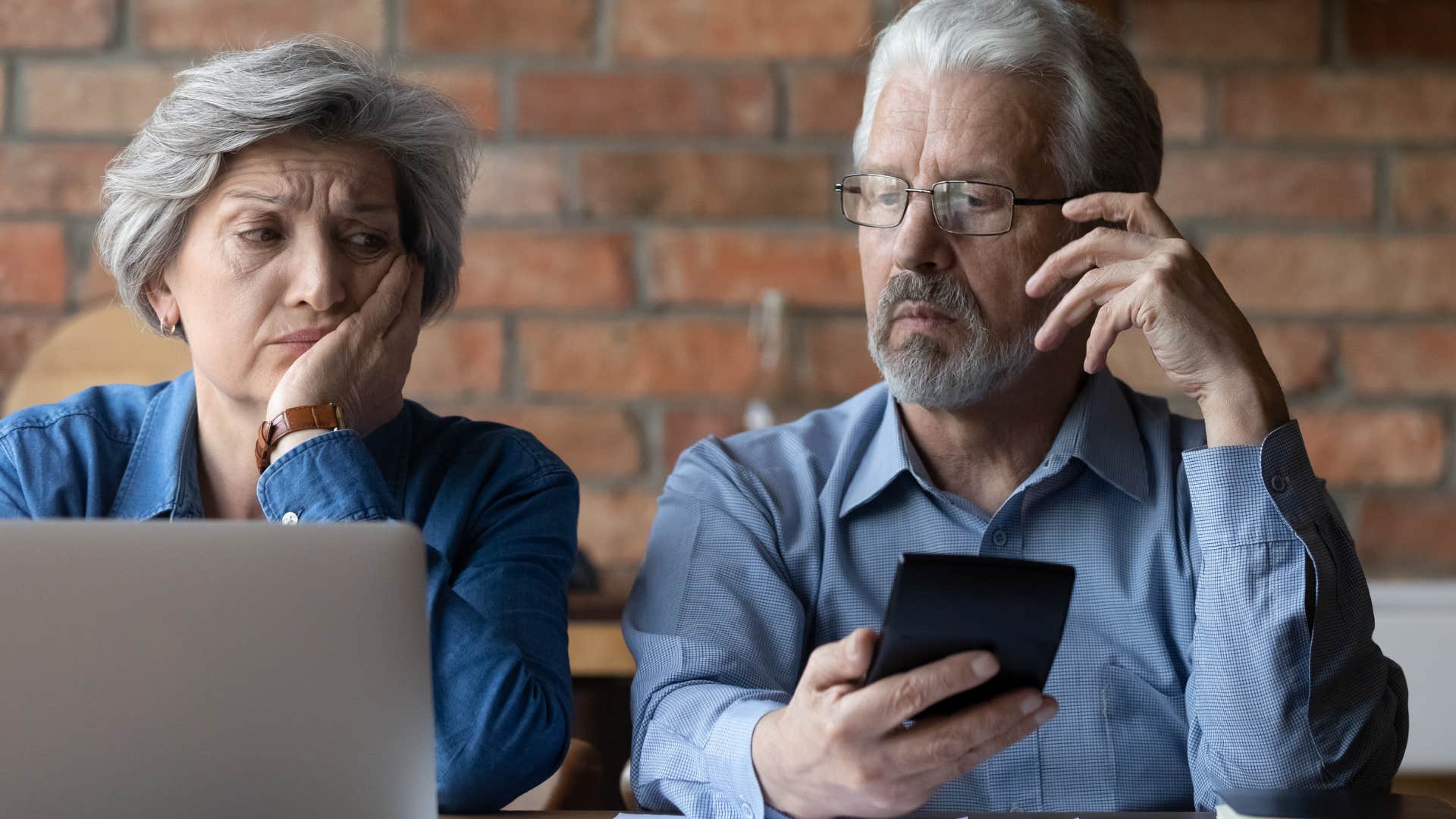 Older couple looking annoyed sitting next to each other