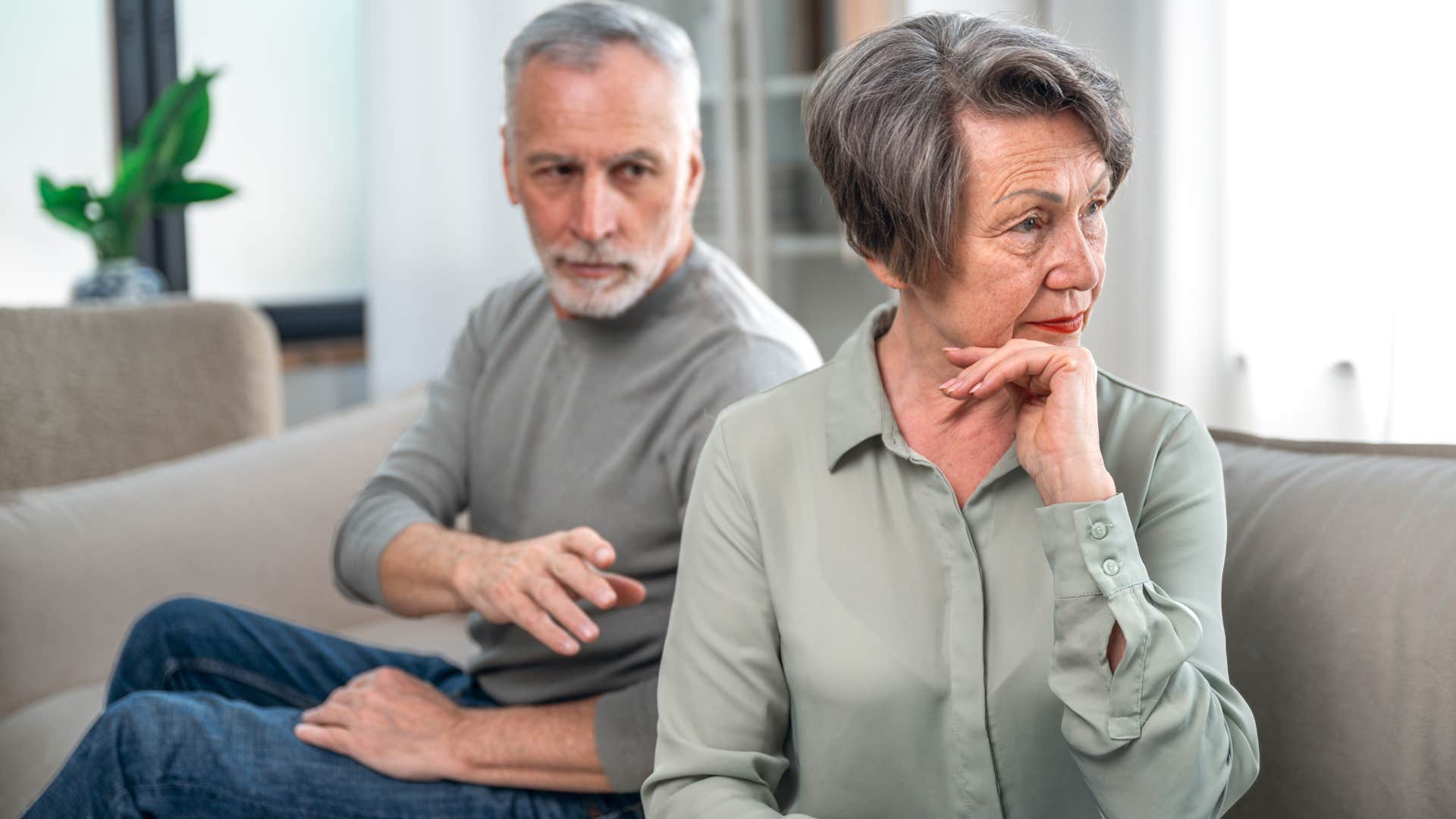 Annoyed older woman turned away from her husband.