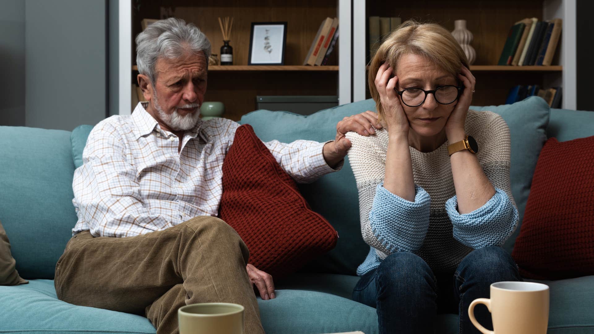 Man comforting his upset wife on a couch