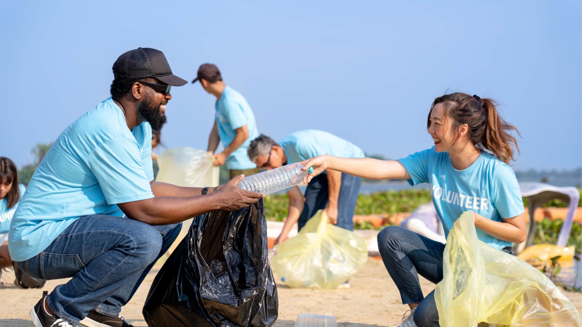 Man and woman clean up a beach for environmental sustainability