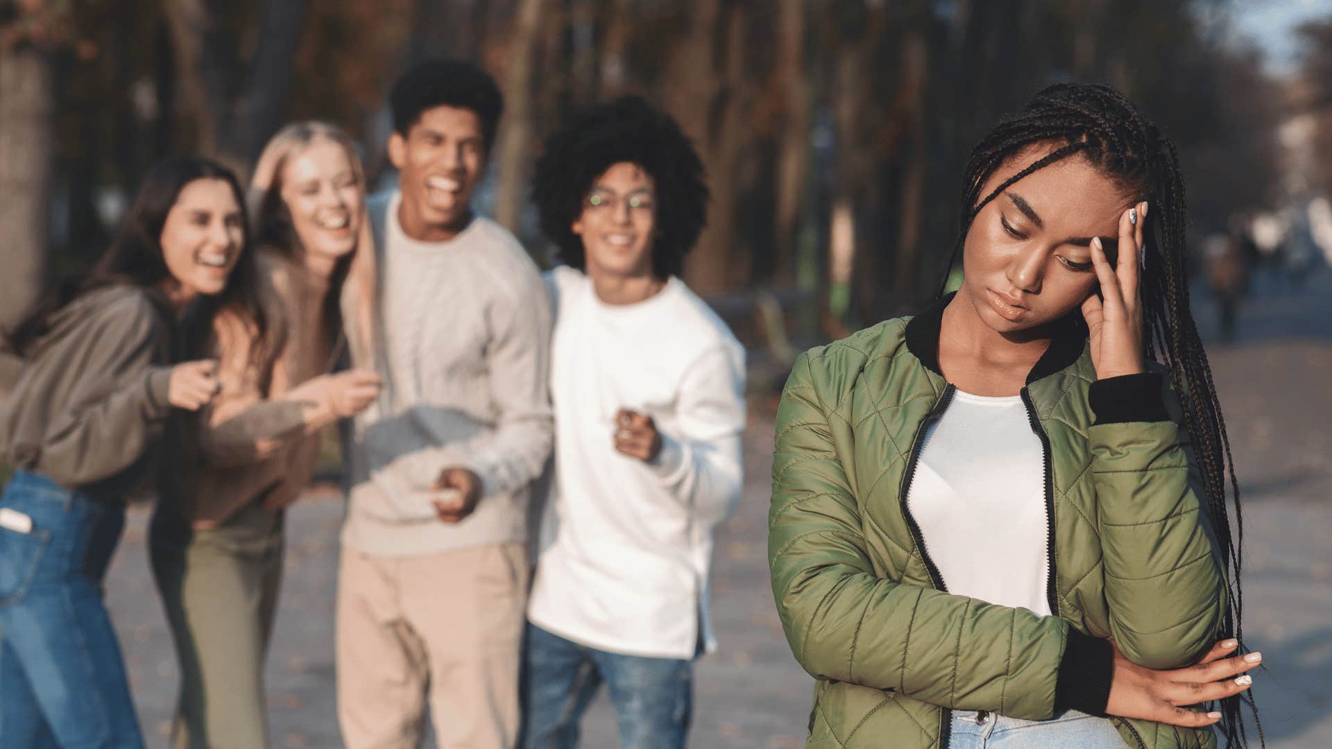 Group of teenagers taunts another teen with trash talk