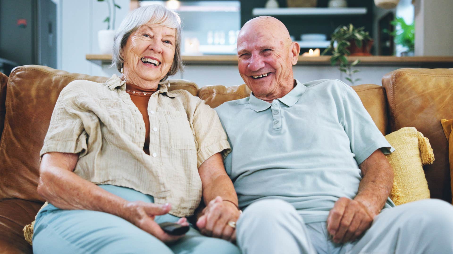 older couple smiling and watching TV together