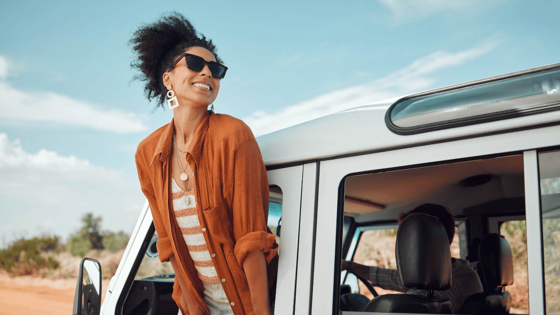 Adventurous woman leans out of vehicle window