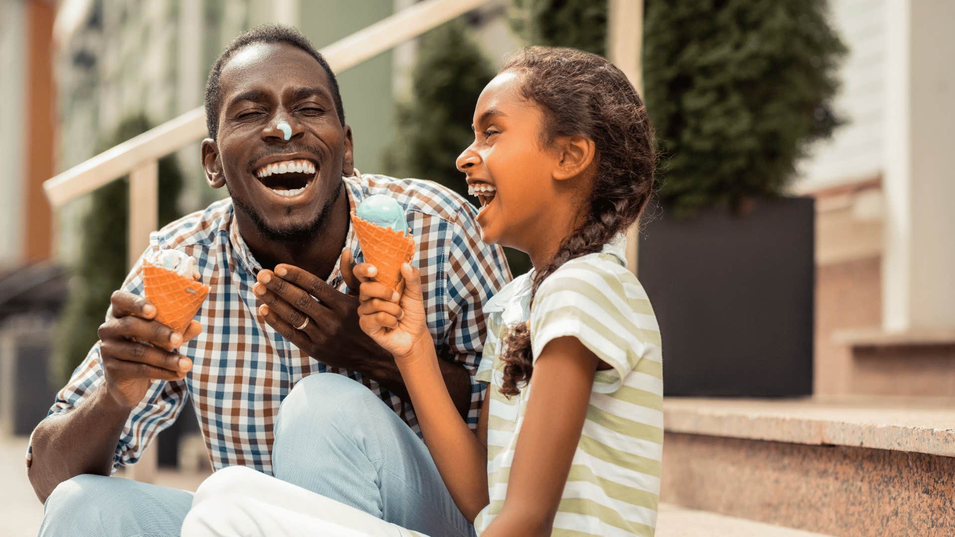 happy man eating ice cream with smiling daughter