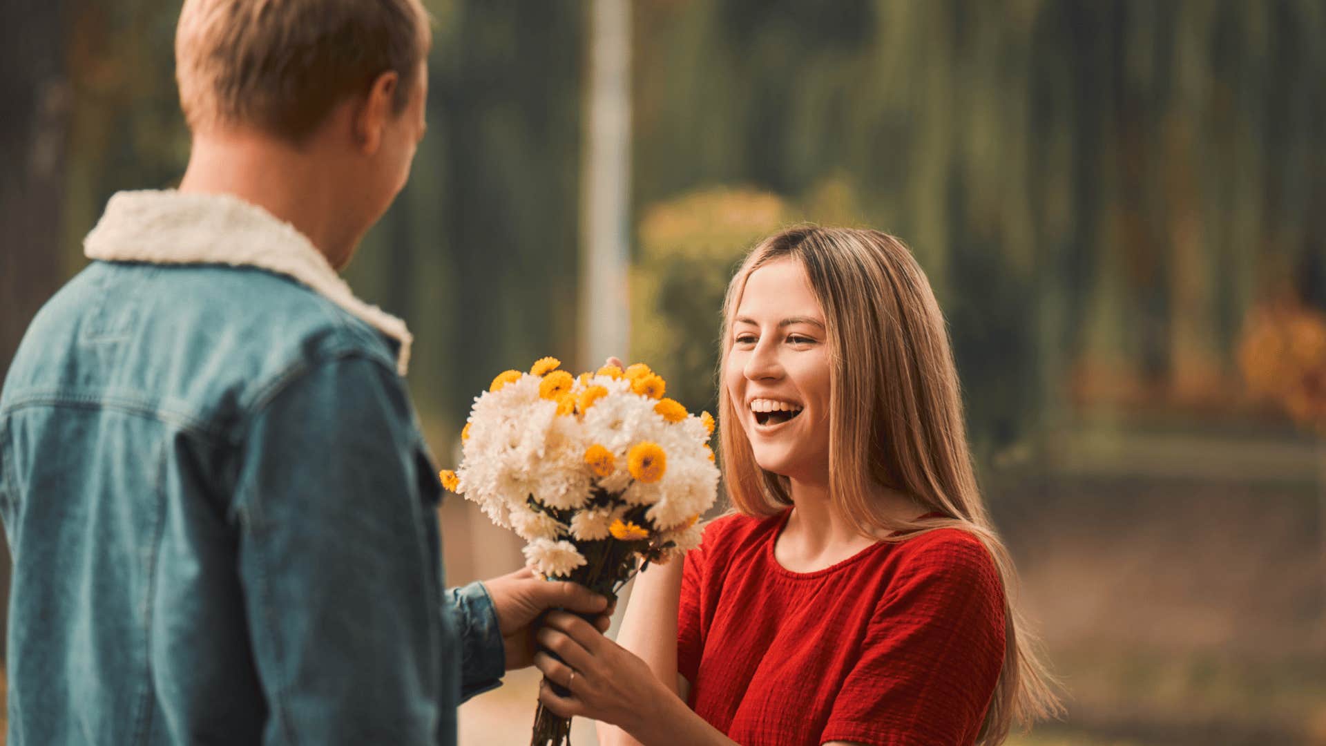 romantic man giving woman a bouquet of flowers