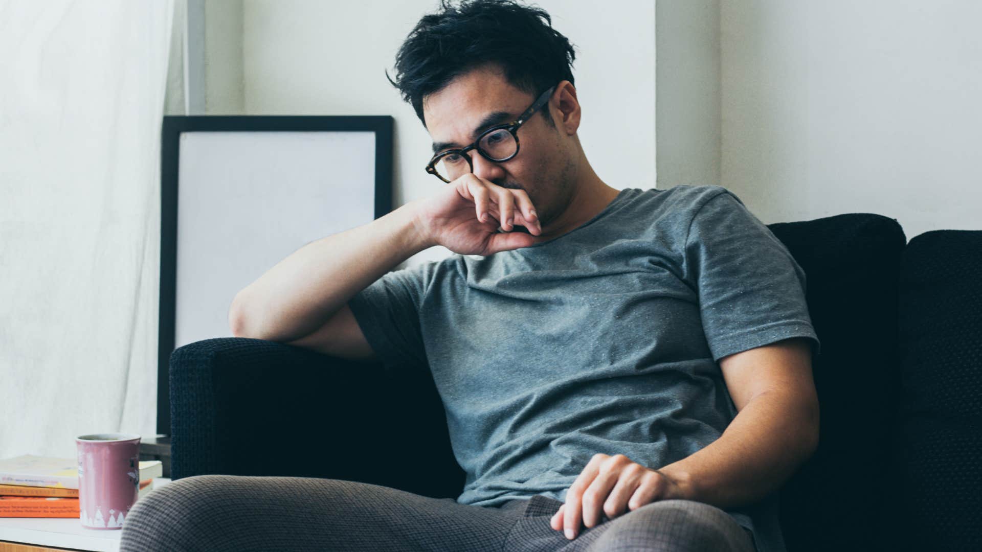 man feeling sad sitting on couch