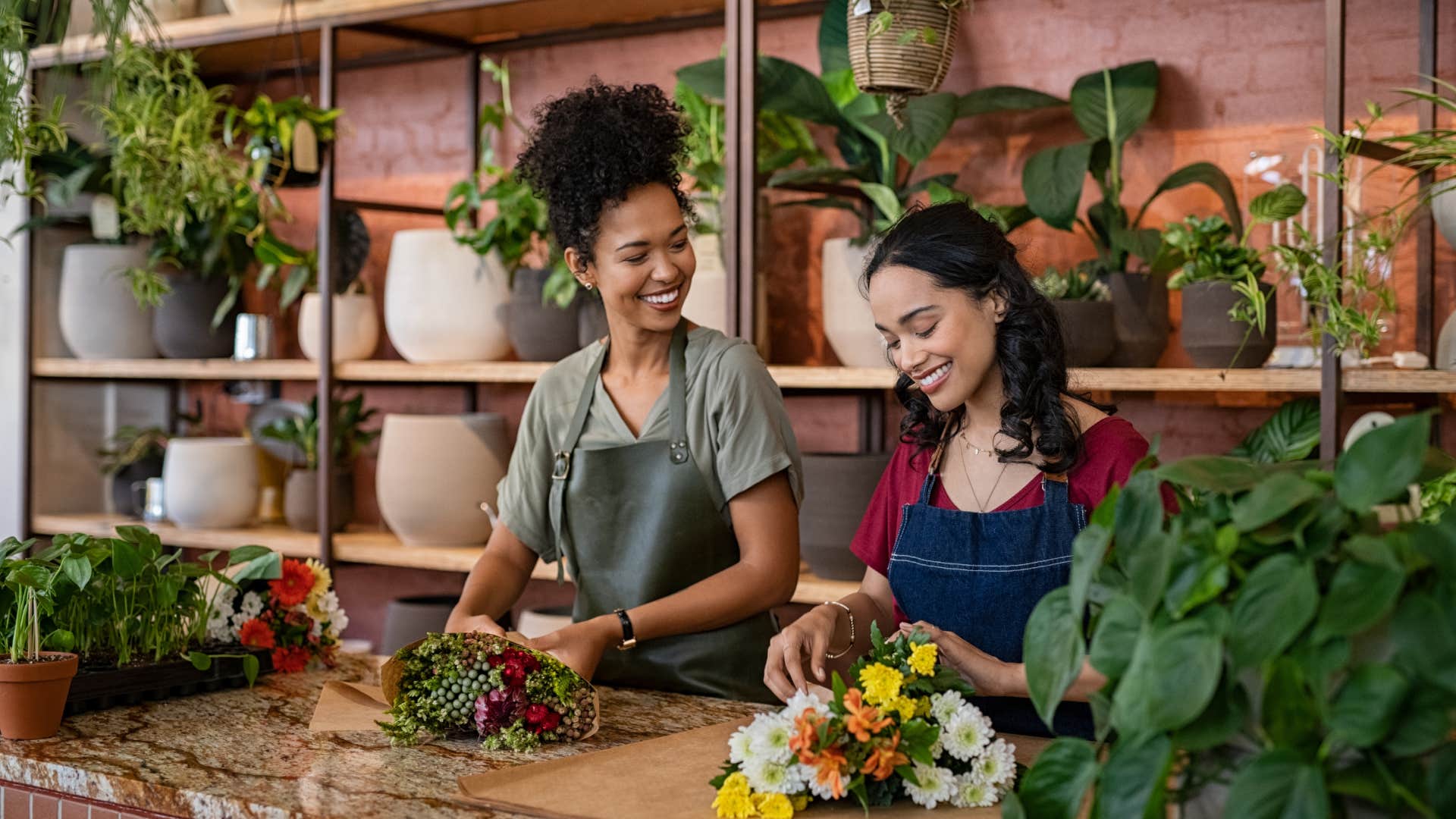 two middle class women putting together flower bouquets in their community