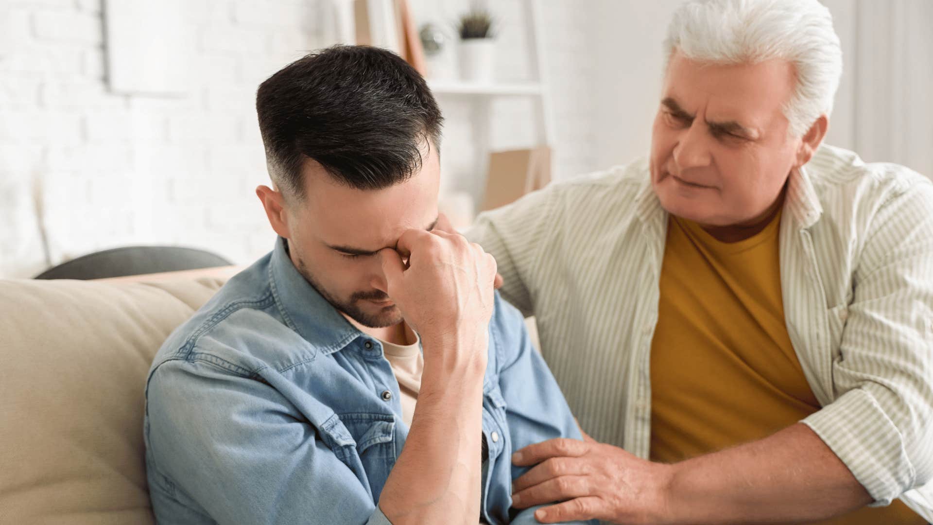 older father trying to comfort upset crying son