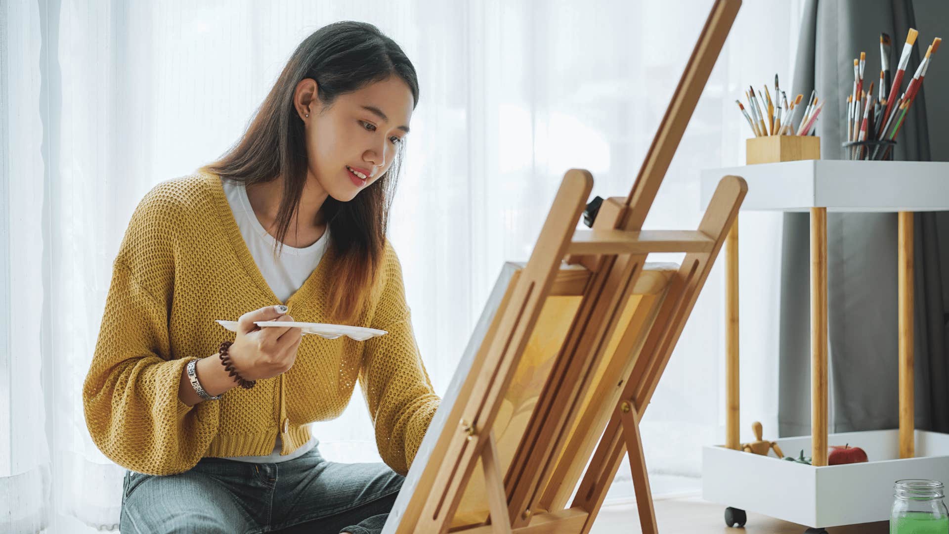 woman painting on easel as her hobby