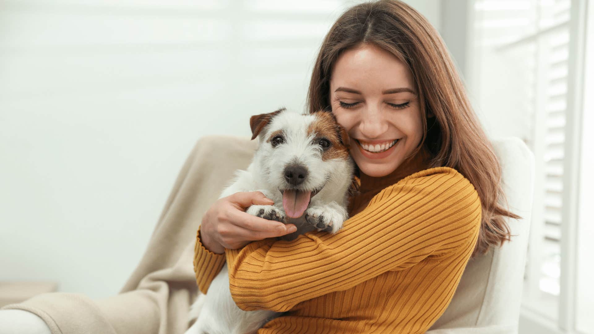 woman smiling hugging her dog