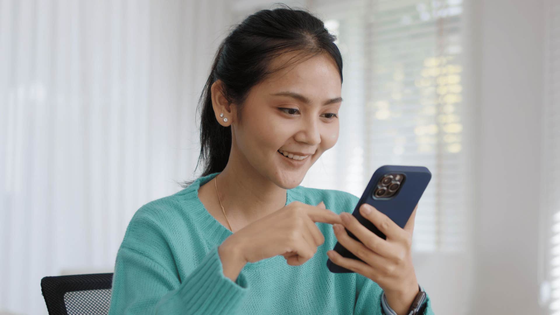 woman smiling while texting