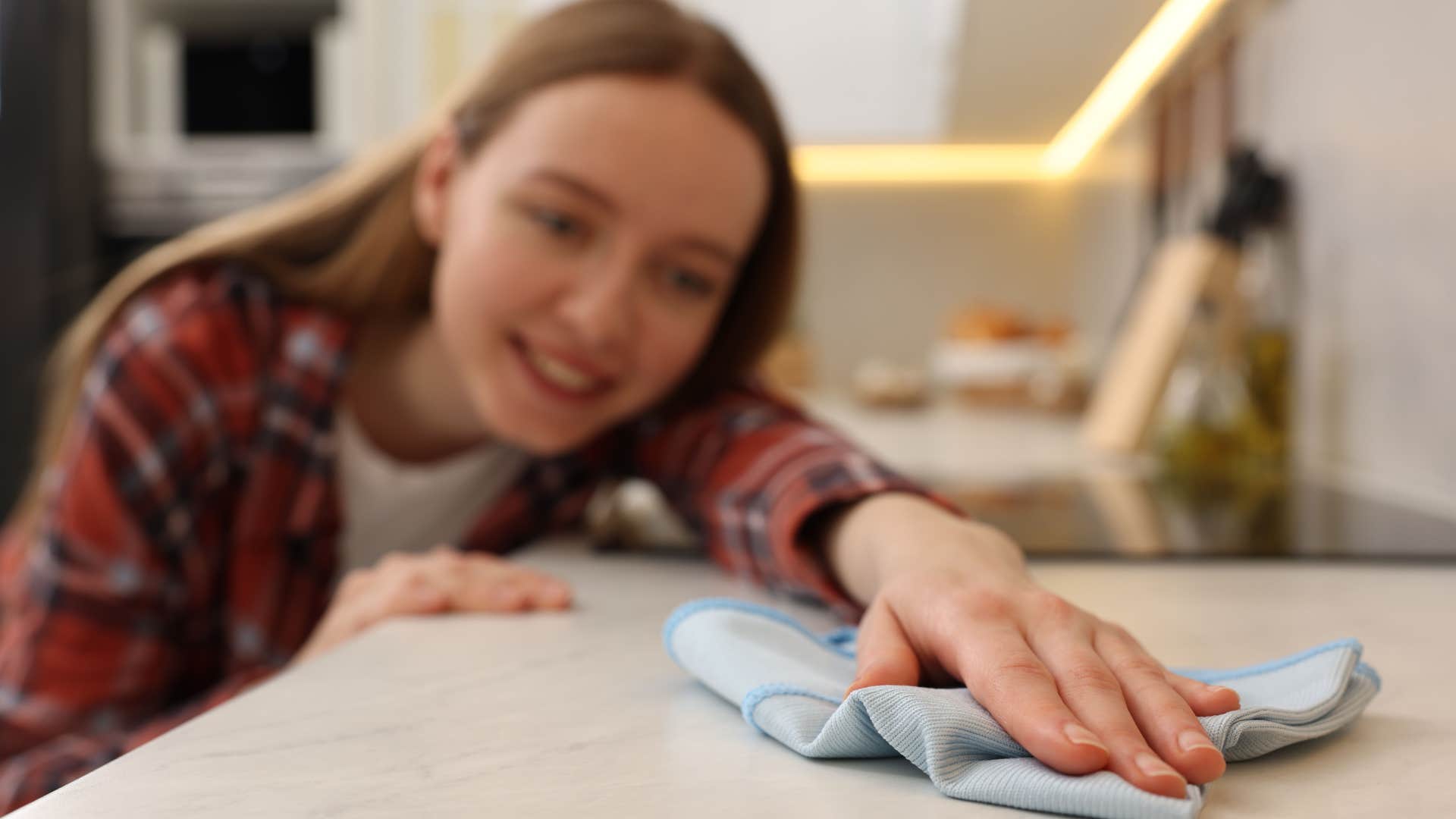 woman wiping marble countertop