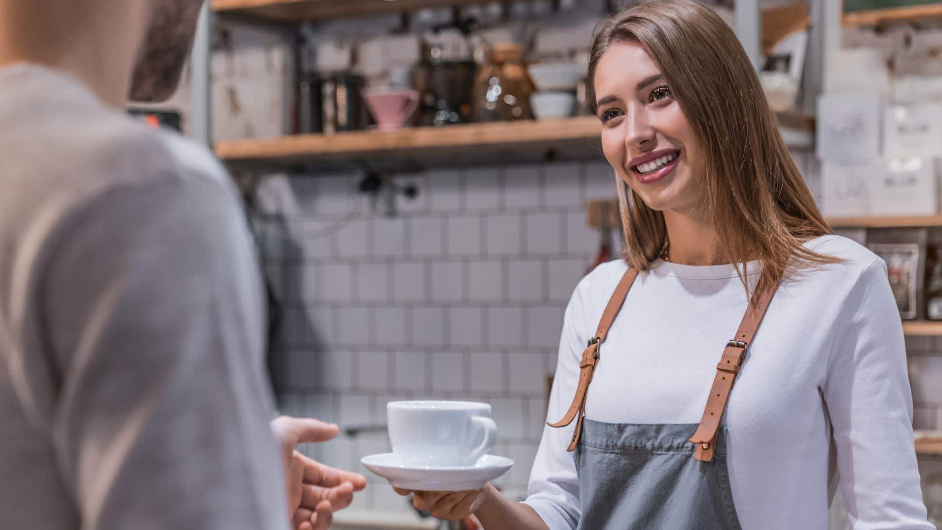 woman handing man a coffee