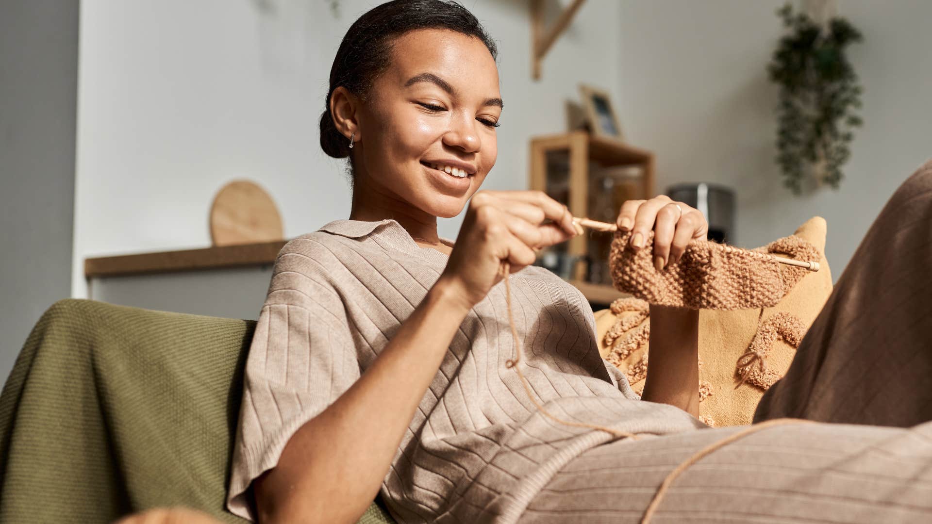 woman crocheting on a couch