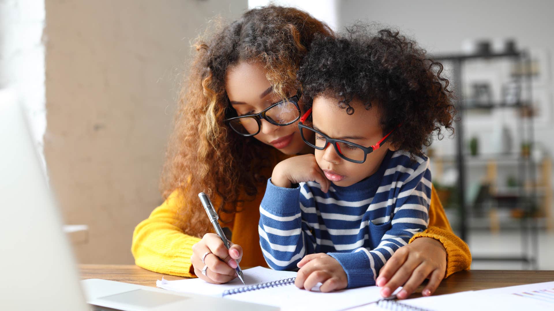 woman helping her young son with homework