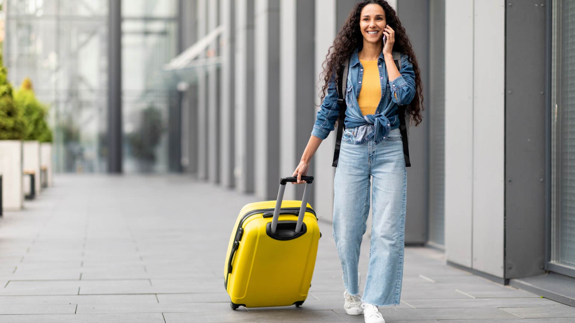 woman carrying matching luggage set