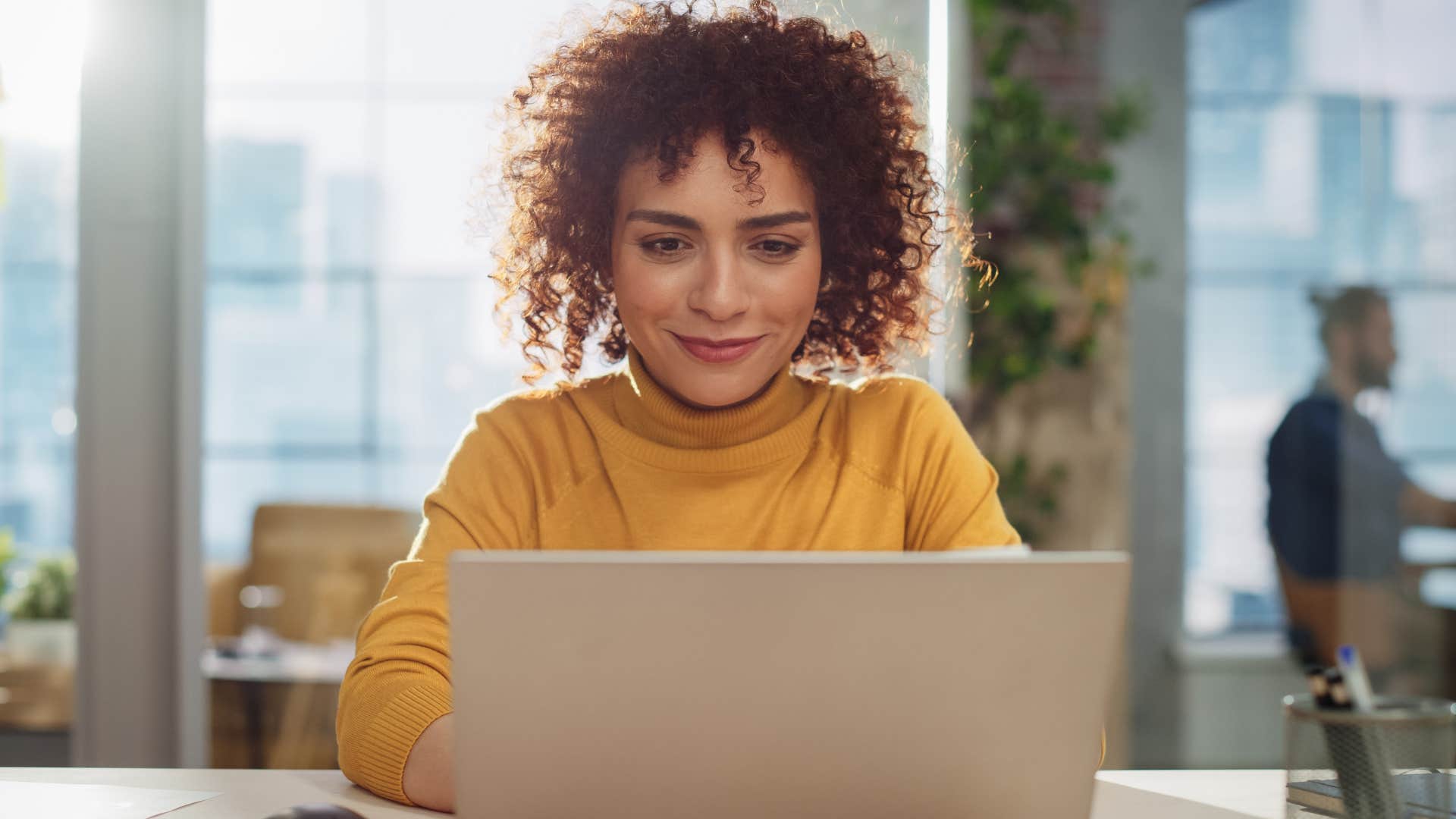 Gen Z woman smiling while working