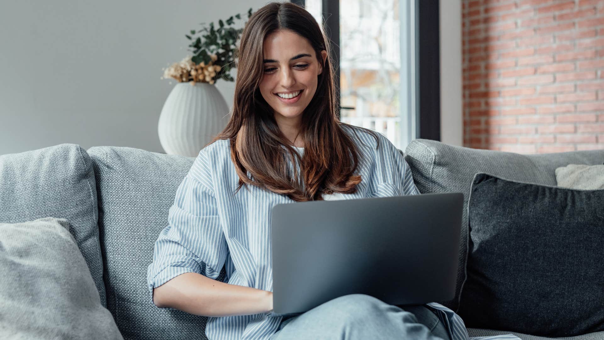 Gen Z woman working from the couch