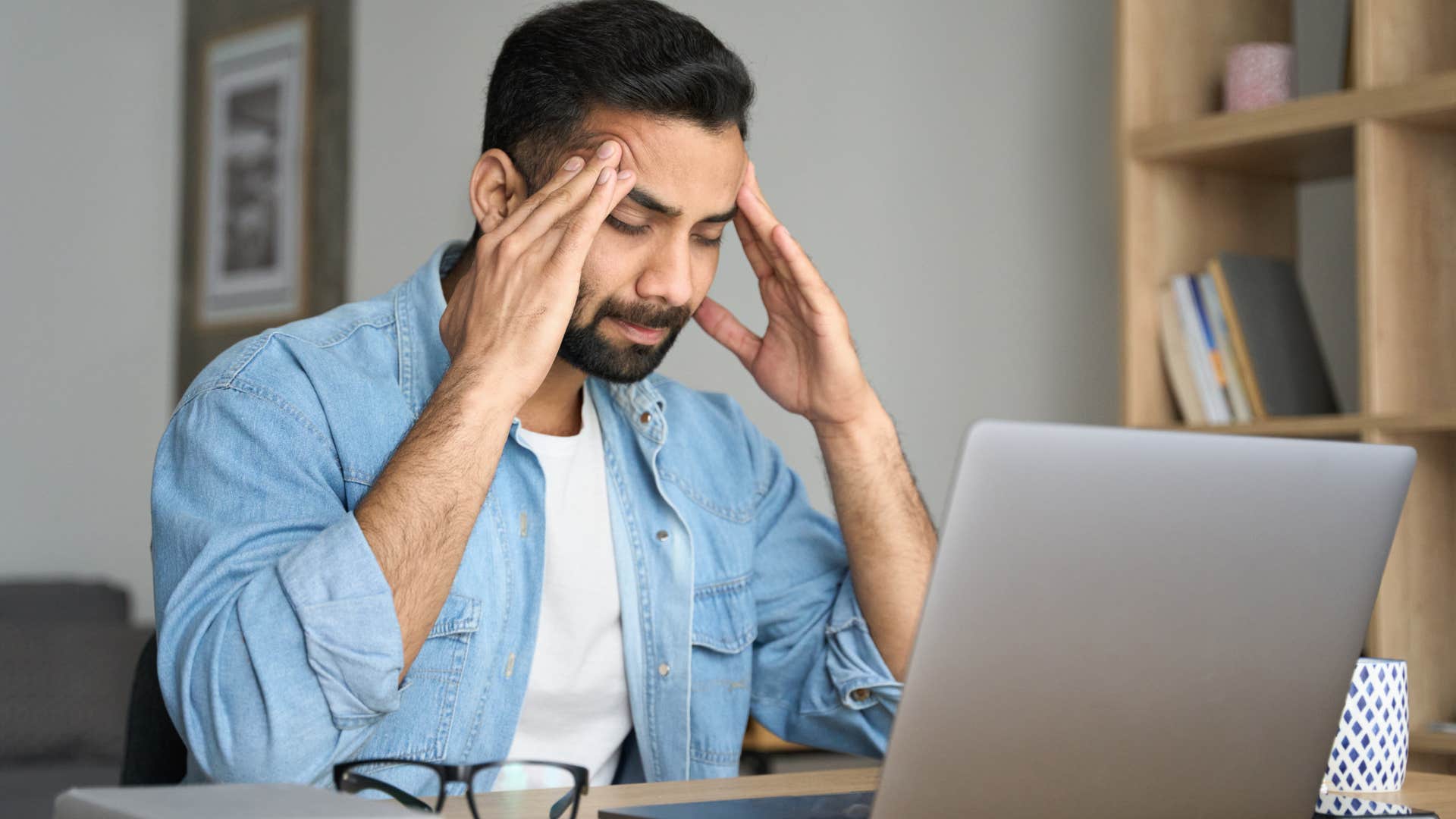 tired Gen Z man sitting in front of his computer