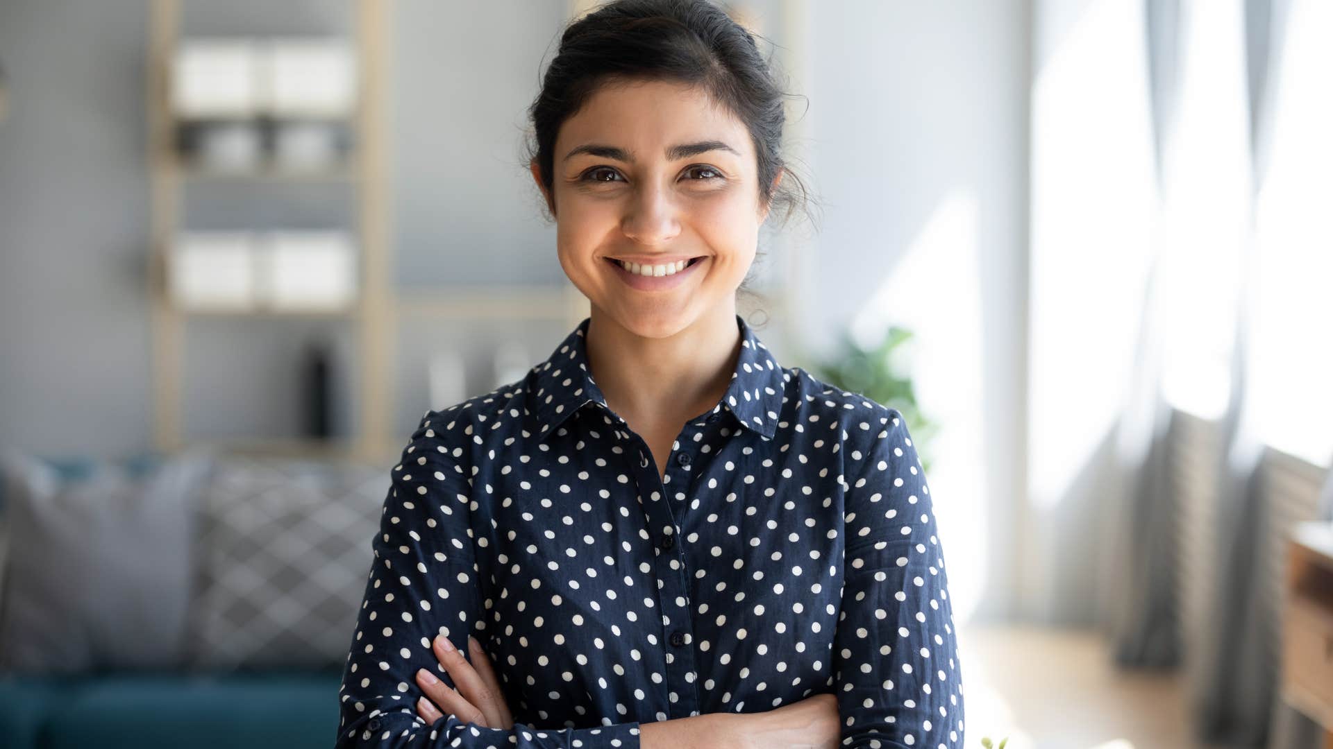 millennial woman smiling with arms crossed