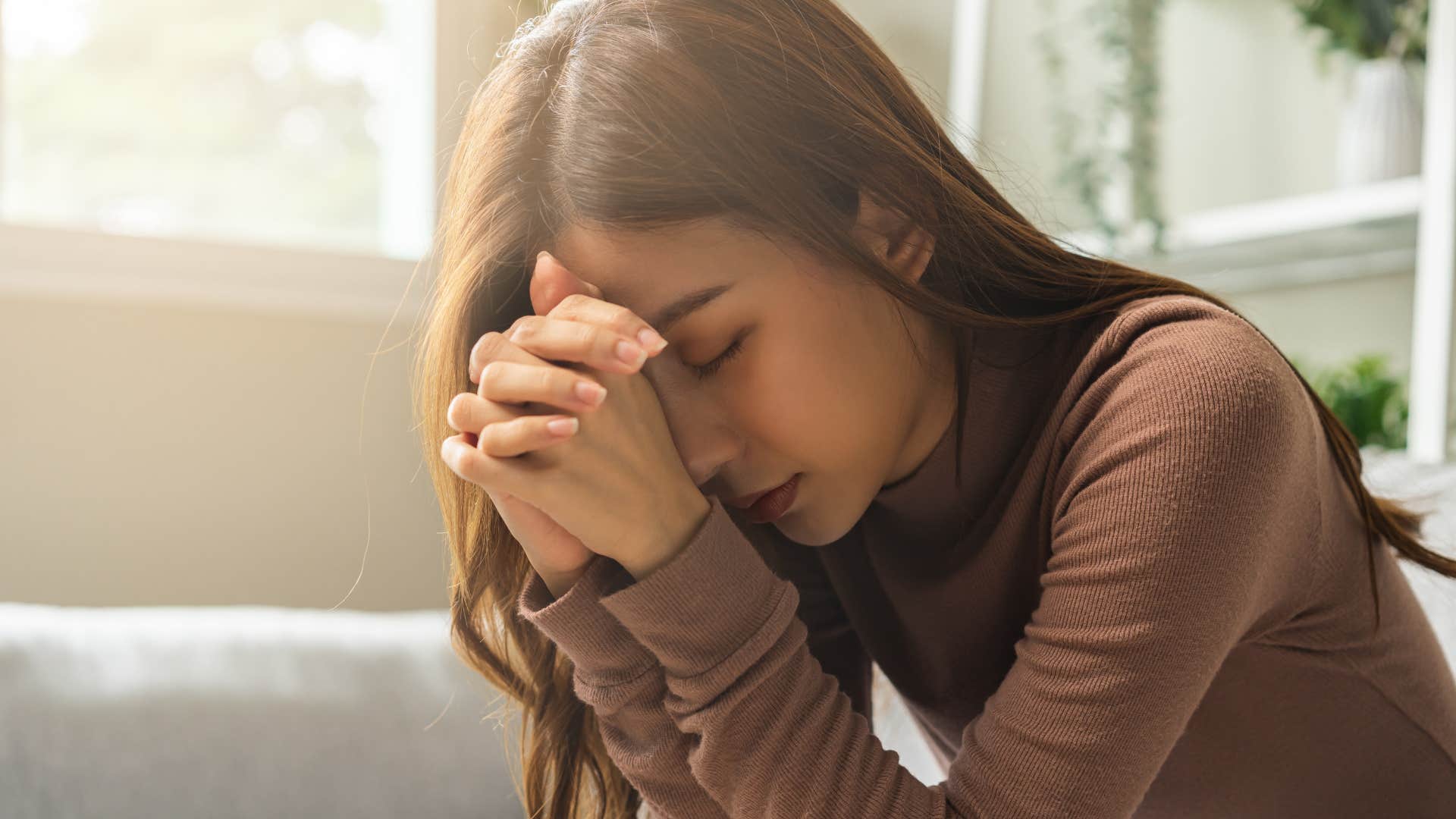 spiritual millennial woman with her head in her hands