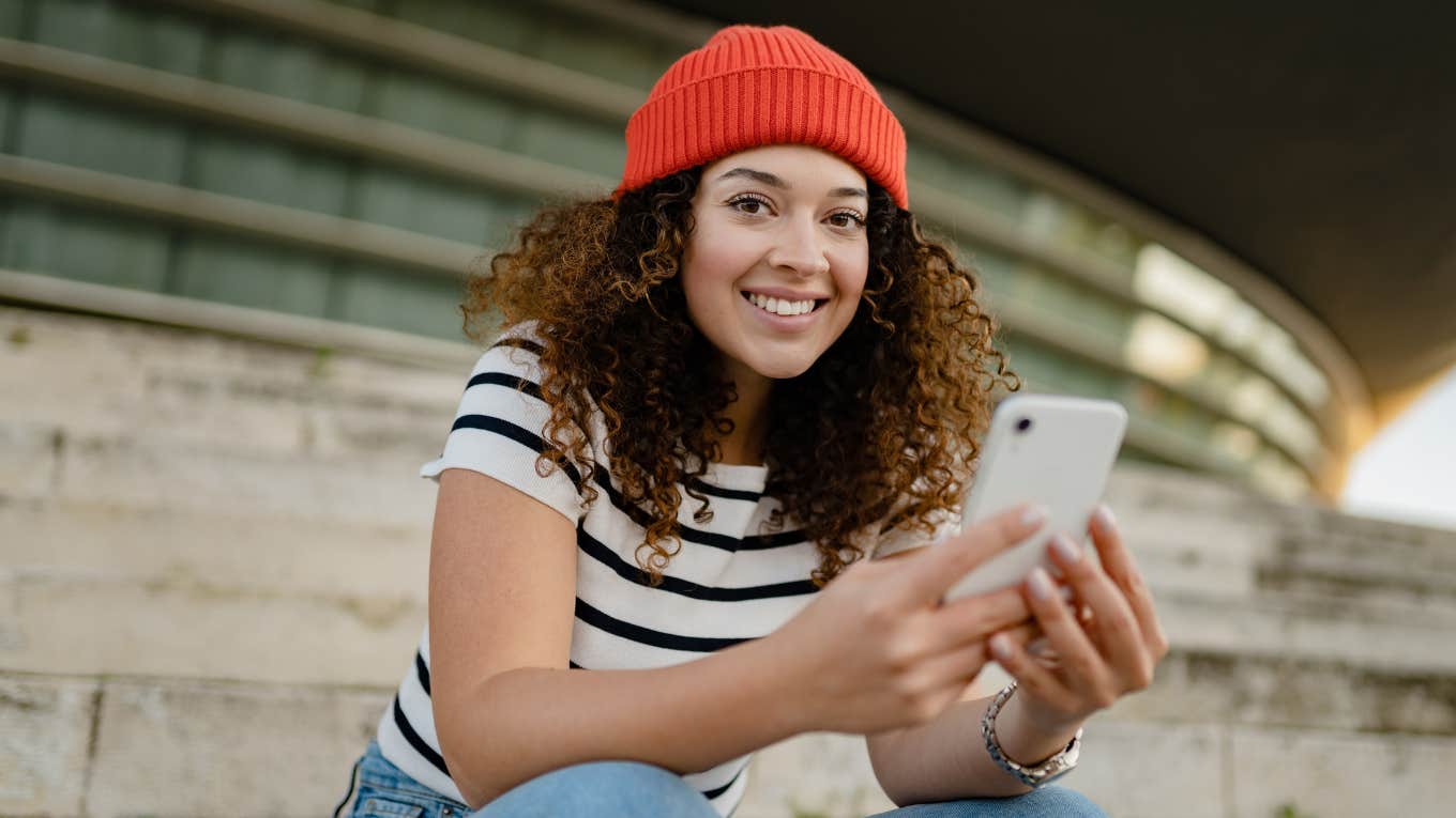 millennial woman sitting on stairs on her phone